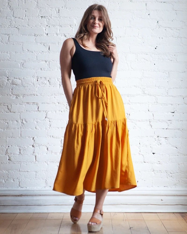 True Bias Mave Skirt sewing pattern in lightweight drapey fabric, featuring elastic waist, drawstring, inseam pockets, and optional ruffle hem in various lengths.