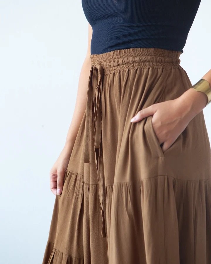 True Bias Mave Skirt sewing pattern in lightweight drapey fabric, featuring elastic waist, drawstring, inseam pockets, and optional ruffle hem in various lengths.