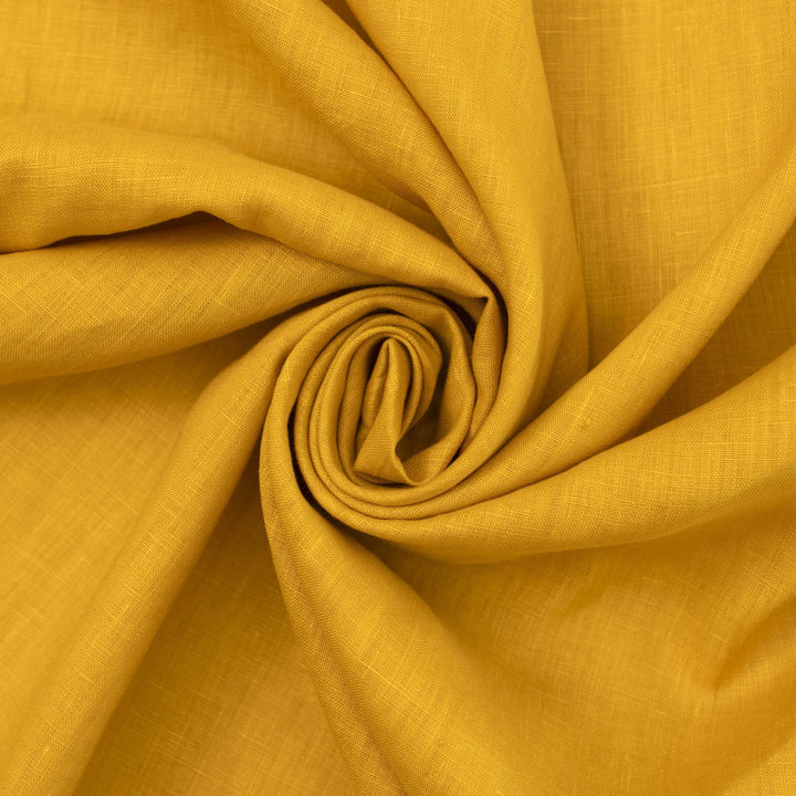 Bright summer marigold linen fabric with soft drape, breathable texture, and lightweight feel for sewing dresses, skirts, and summer apparel.