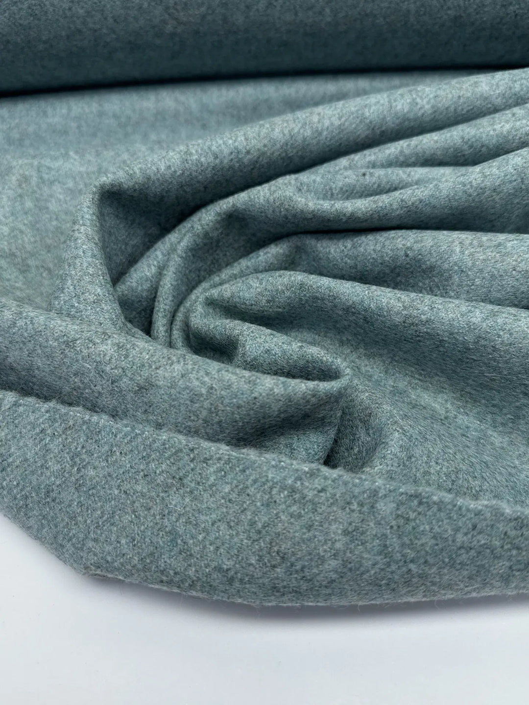 Close-up of Wool Suiting fabric in mottled slate blue, made from 100% high-quality wool, ideal for tailored suits and coats.
