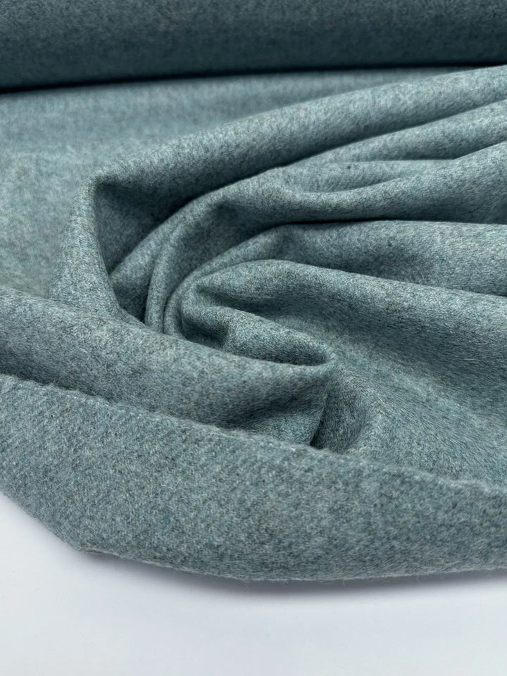 Close-up of Wool Suiting fabric in mottled slate blue, made from 100% high-quality wool, ideal for tailored suits and coats.