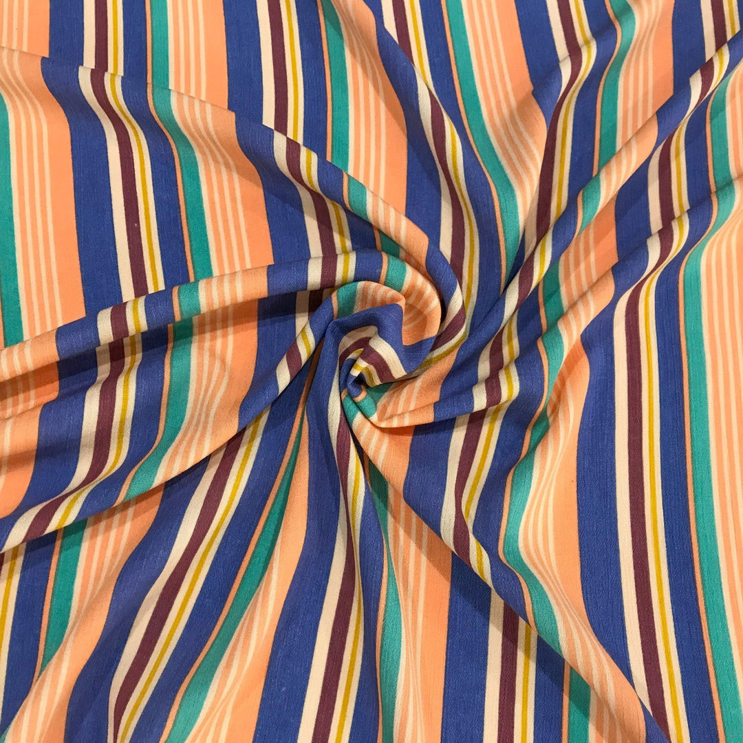 Rayon Crepe Cabana Stripe fabric in peach, periwinkle, and mint colors with flowing drape