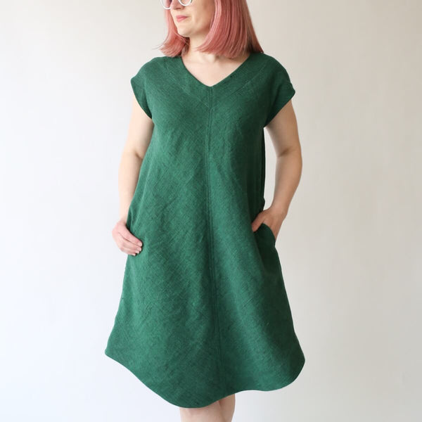 Made By Rae Emerald Dress pattern featuring a V-shaped neckline, curved hem, and optional pockets
