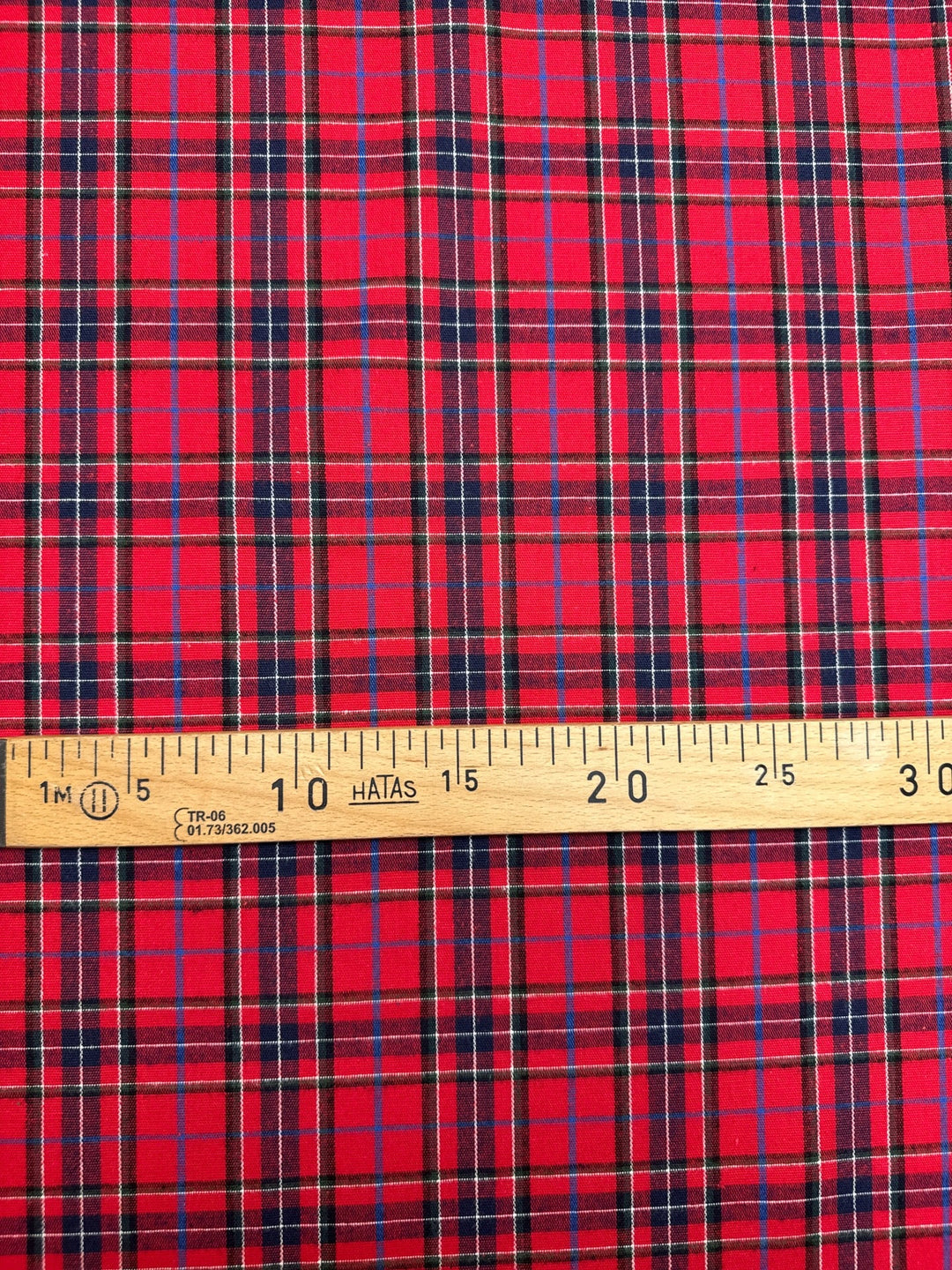 Italian cotton flannel fabric in bright red and black plaid, lightweight textile for shirts, blouses, and casual wear.