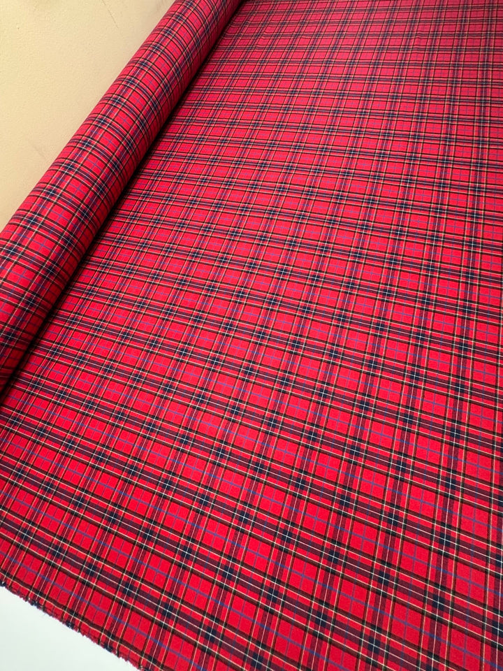 Italian cotton flannel fabric in bright red and black plaid, lightweight textile for shirts, blouses, and casual wear.