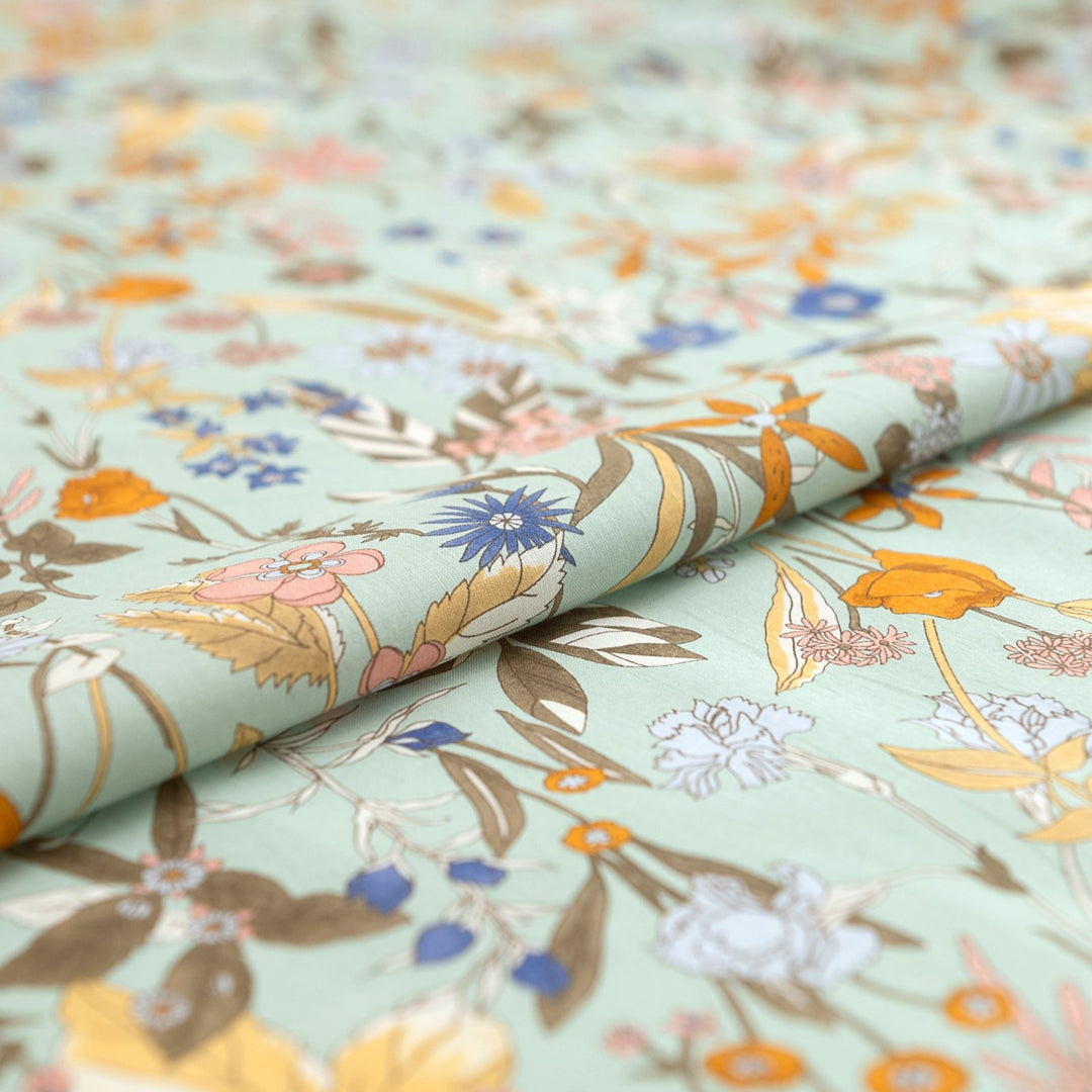 Japanese Cotton Poplin fabric by Hokkoh with green base and colorful lily floral print – soft lightweight cotton for dresses, blouses, and skirts