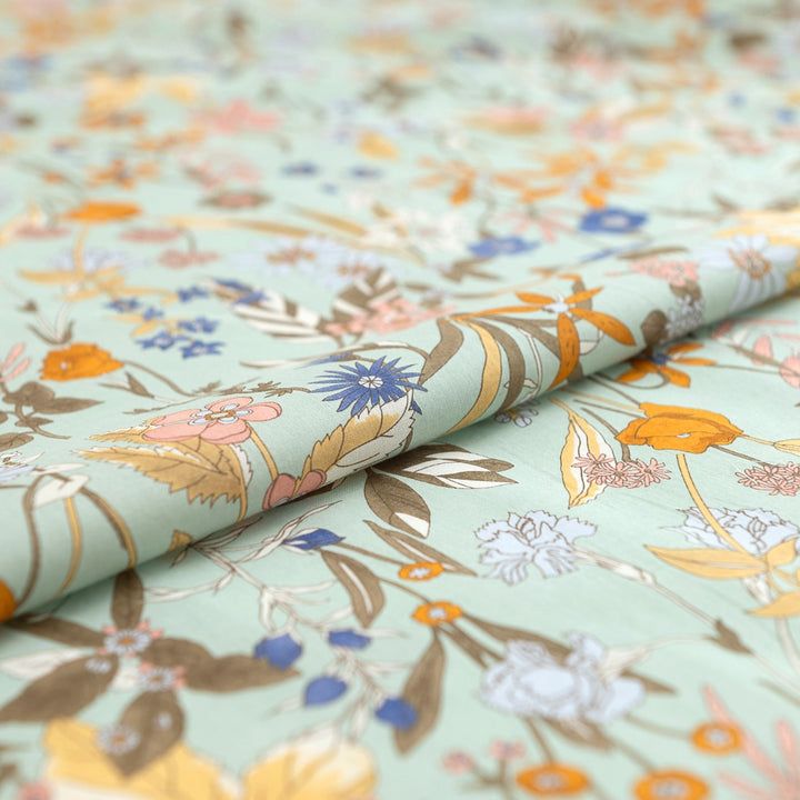 Japanese Cotton Poplin fabric by Hokkoh with green base and colorful lily floral print – soft lightweight cotton for dresses, blouses, and skirts