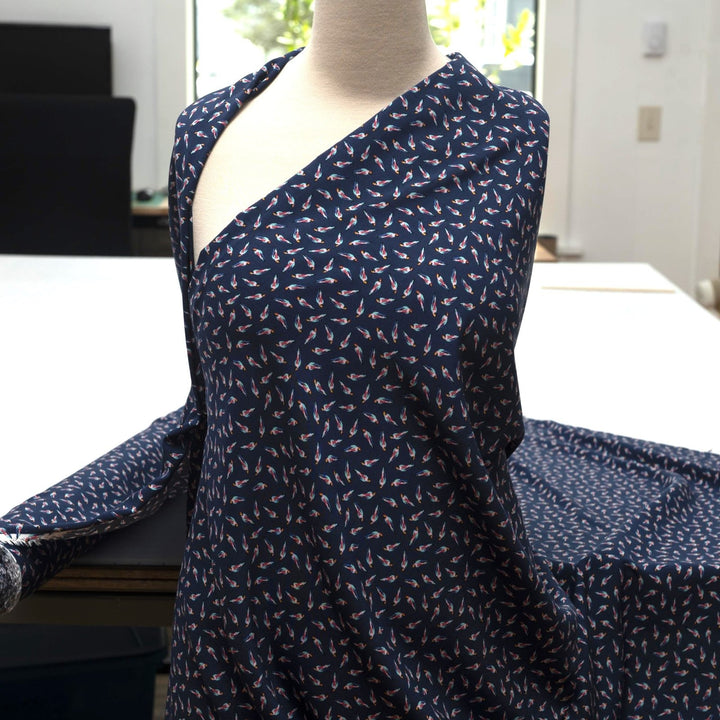 Viscose Challis fabric in navy blue with whimsical parrot print for lightweight summer dresses, skirts, and loungewear