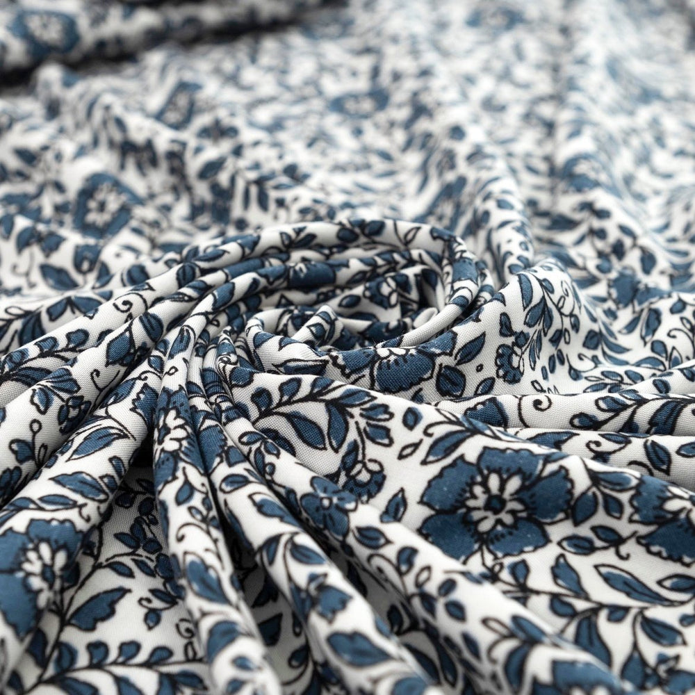Rayon Challis Indigo Blossom Breeze fabric with indigo floral outline on white background, lightweight and soft drape textile for dresses, blouses, and skirts