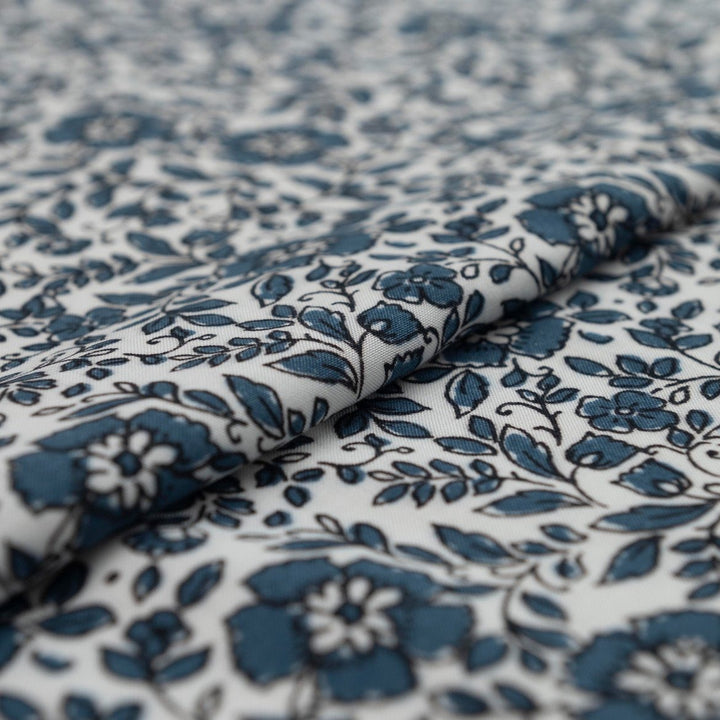 Rayon Challis Indigo Blossom Breeze fabric with indigo floral outline on white background, lightweight and soft drape textile for dresses, blouses, and skirts