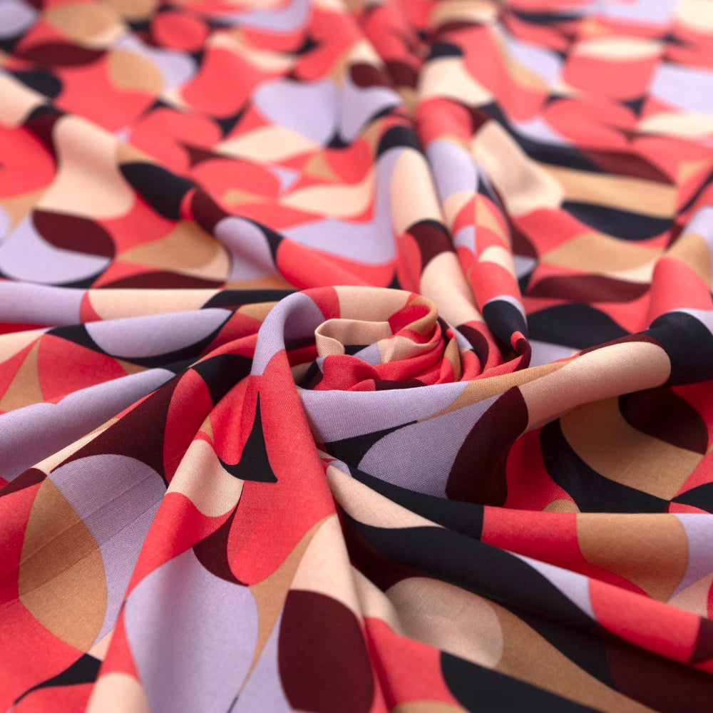 Viscose Challis "Kaleidoscope Bright" fabric featuring vibrant geometric shapes in pink, purple, black, and taupe, 58-inch width, perfect for dresses and summer garments