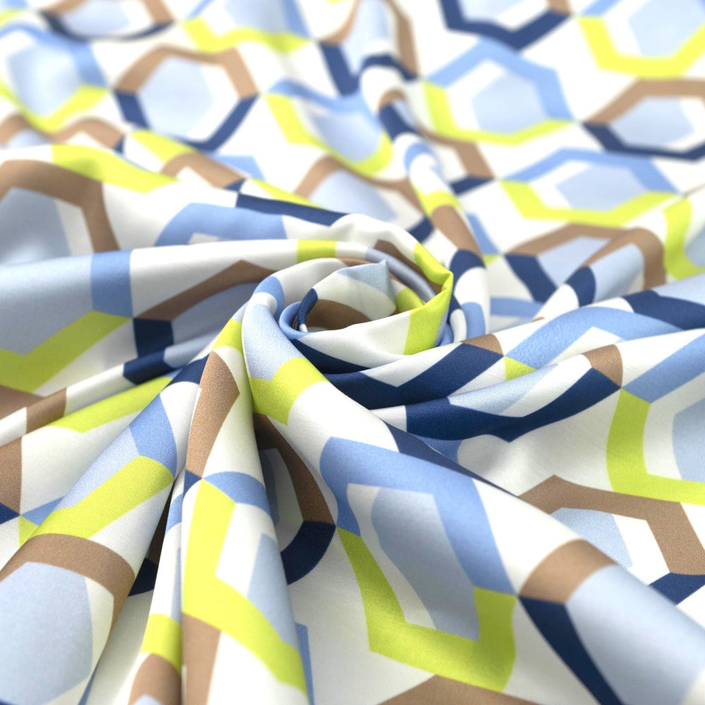 Viscose Sateen Prism Play fabric with geometric shapes in white, blue, and green, luxurious smooth drape and subtle sheen