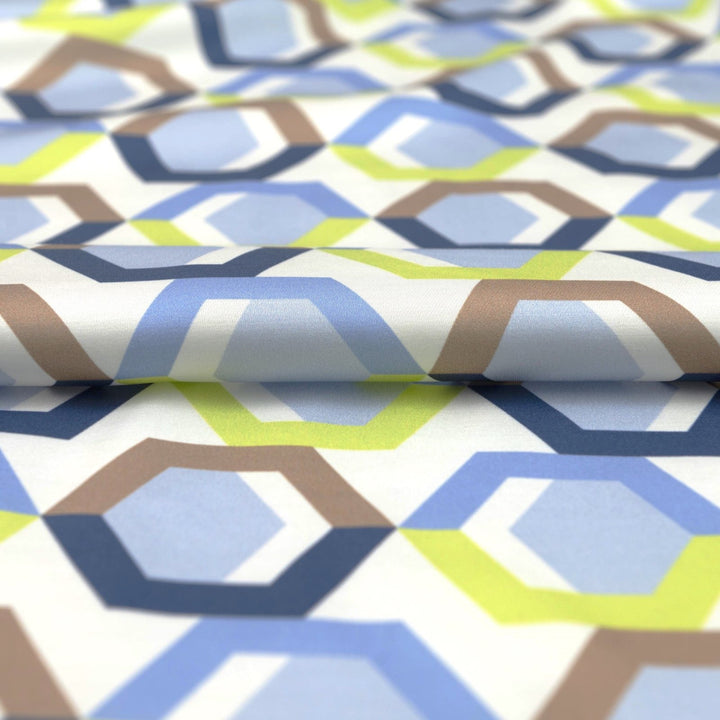 Viscose Sateen Prism Play fabric with geometric shapes in white, blue, and green, luxurious smooth drape and subtle sheen