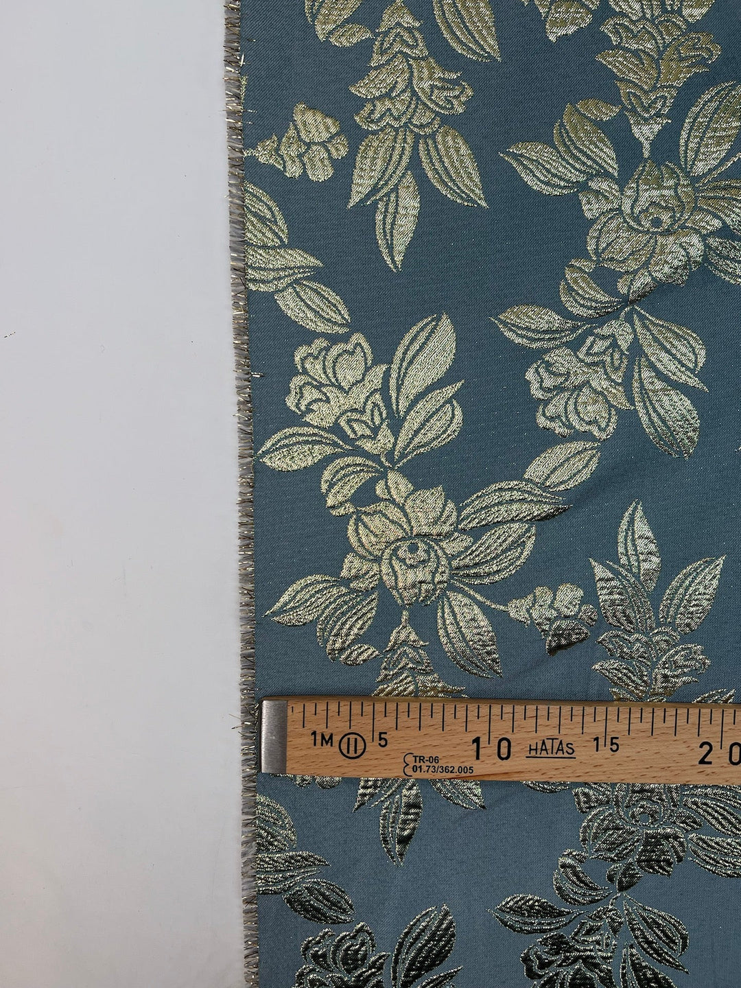 French jacquard fabric with metallic leaf pattern in teal and gold, polyester lurex acrylic blend, ideal for bridal gowns, evening dresses, and formalwear.