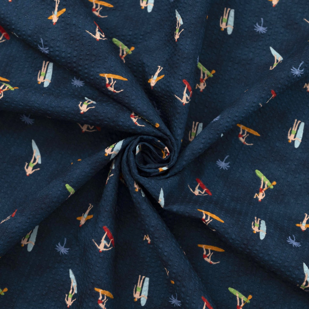 Cotton Seersucker Tiny Surfers – 100% cotton, 44 inches wide, navy seersucker with tiny surfer print, perfect for shirts, shorts, and sundresses