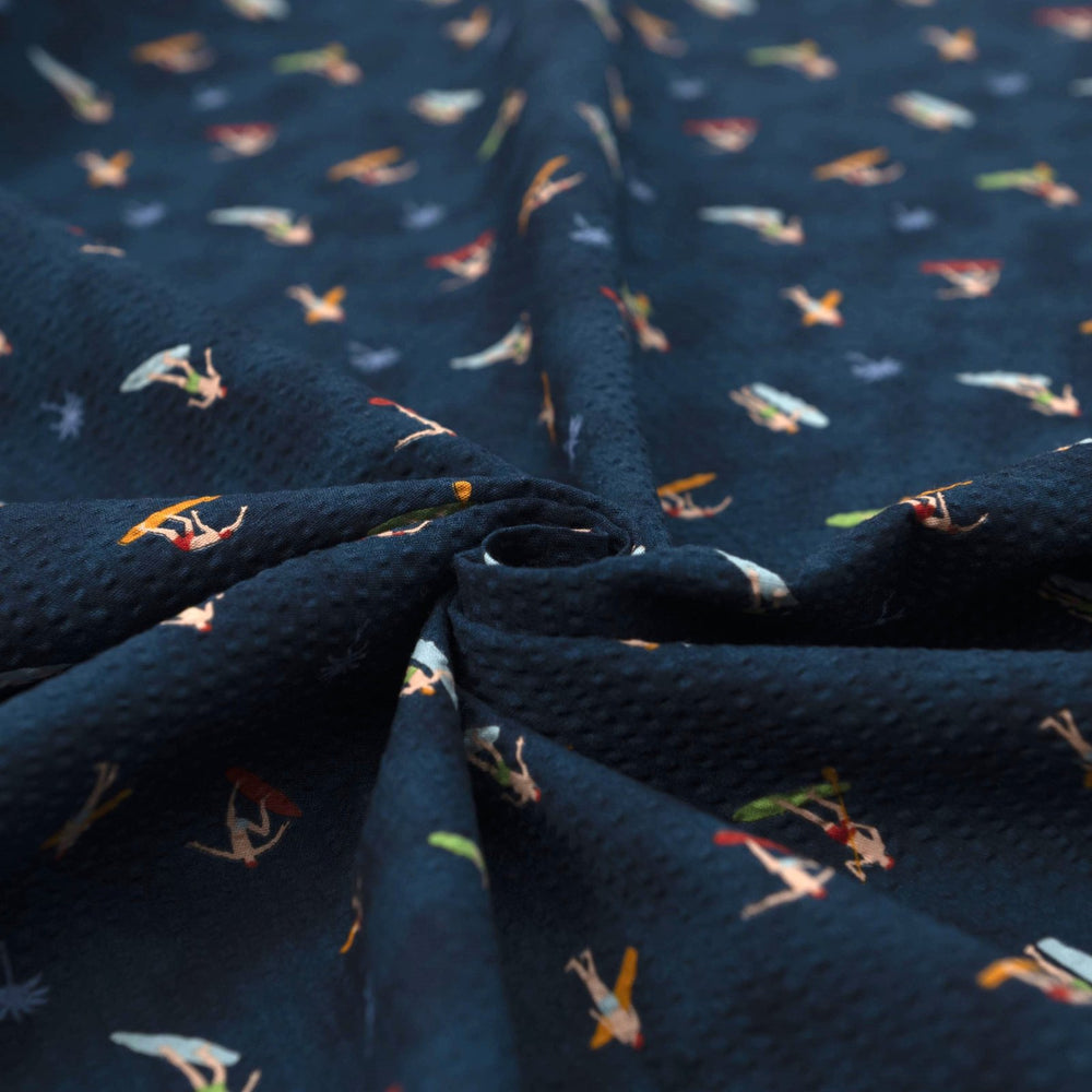 Cotton Seersucker Tiny Surfers – 100% cotton, 44 inches wide, navy seersucker with tiny surfer print, perfect for shirts, shorts, and sundresses
