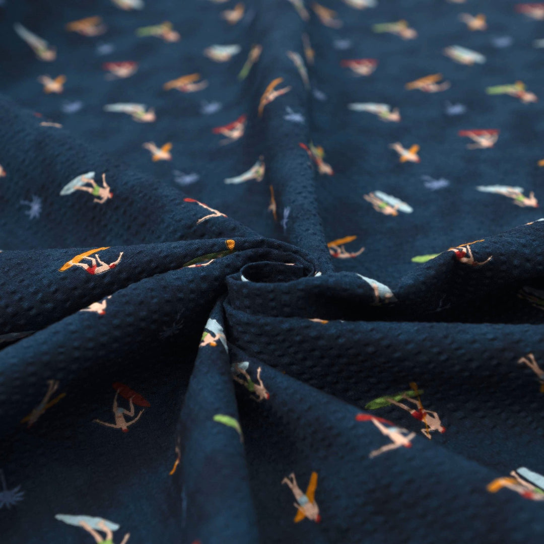 Cotton Seersucker Tiny Surfers – 100% cotton, 44 inches wide, navy seersucker with tiny surfer print, perfect for shirts, shorts, and sundresses