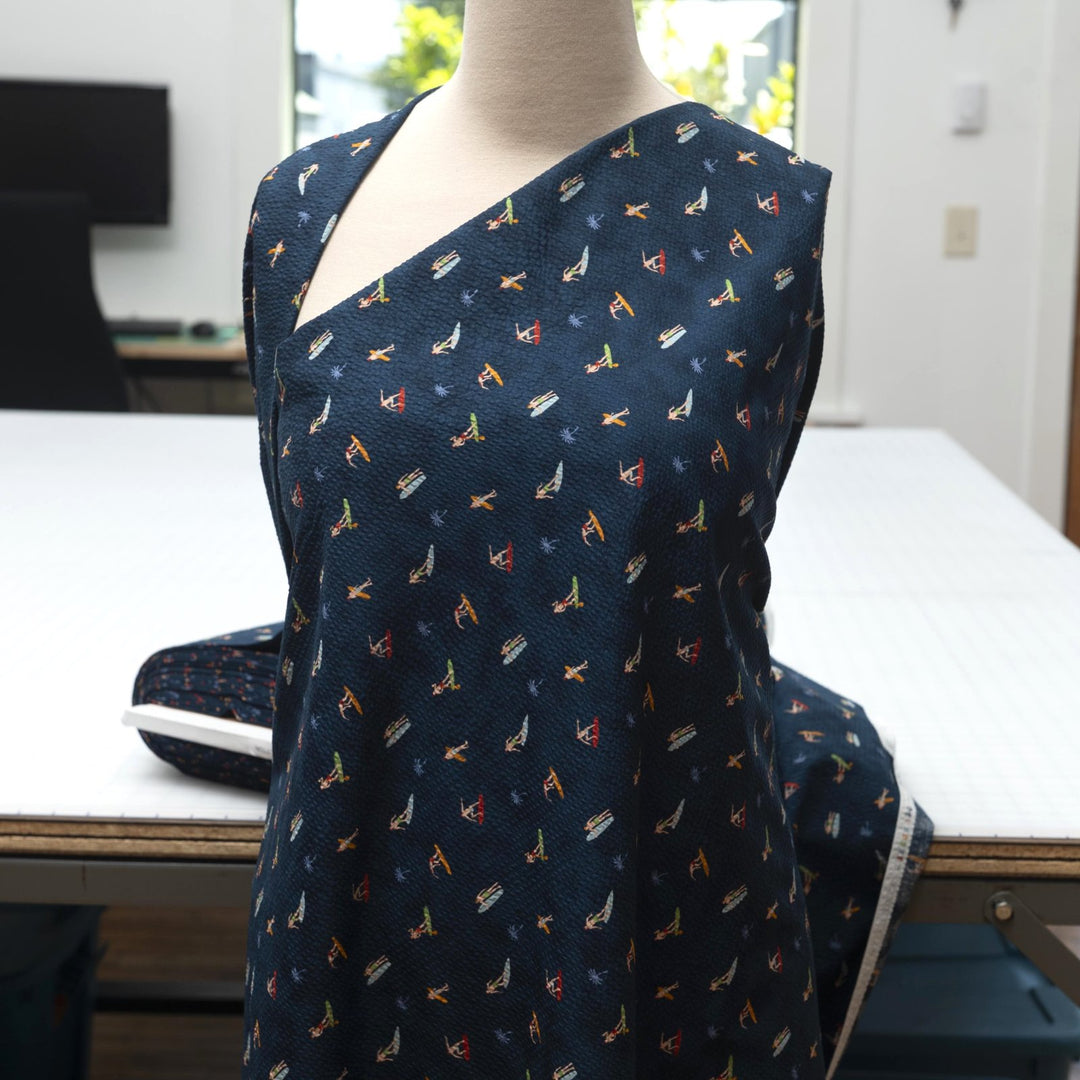 Cotton Seersucker Tiny Surfers – 100% cotton, 44 inches wide, navy seersucker with tiny surfer print, perfect for shirts, shorts, and sundresses