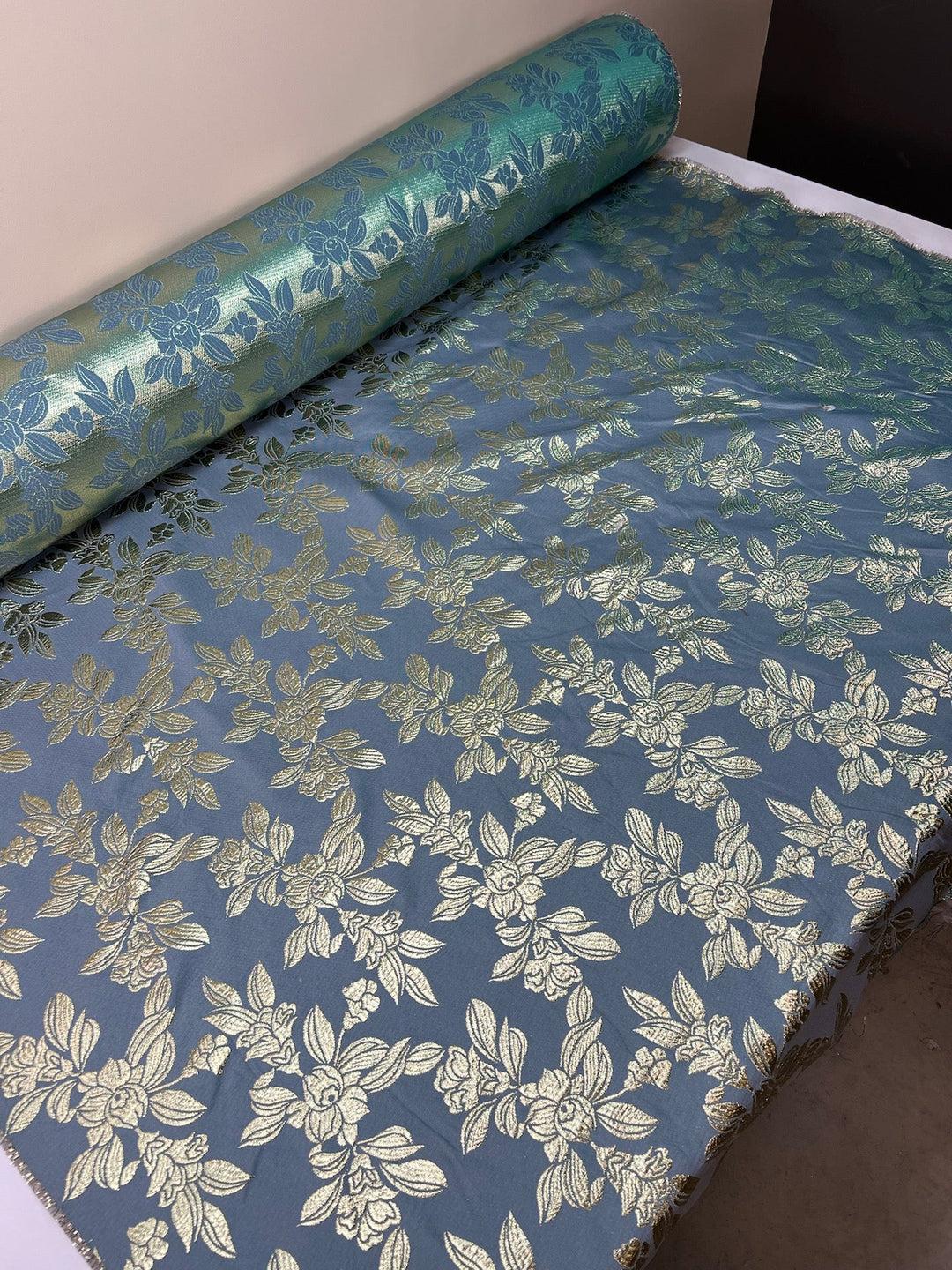 French jacquard fabric with metallic leaf pattern in teal and gold, polyester lurex acrylic blend, ideal for bridal gowns, evening dresses, and formalwear.
