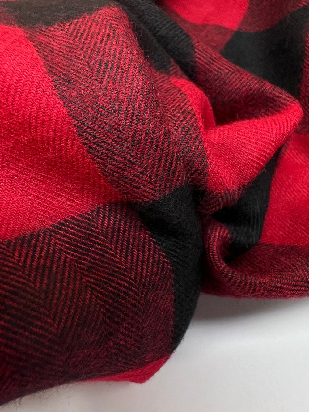 Italian cotton flannel fabric in red and black buffalo plaid, lightweight textile ideal for shirts, blouses, and casual wear.
