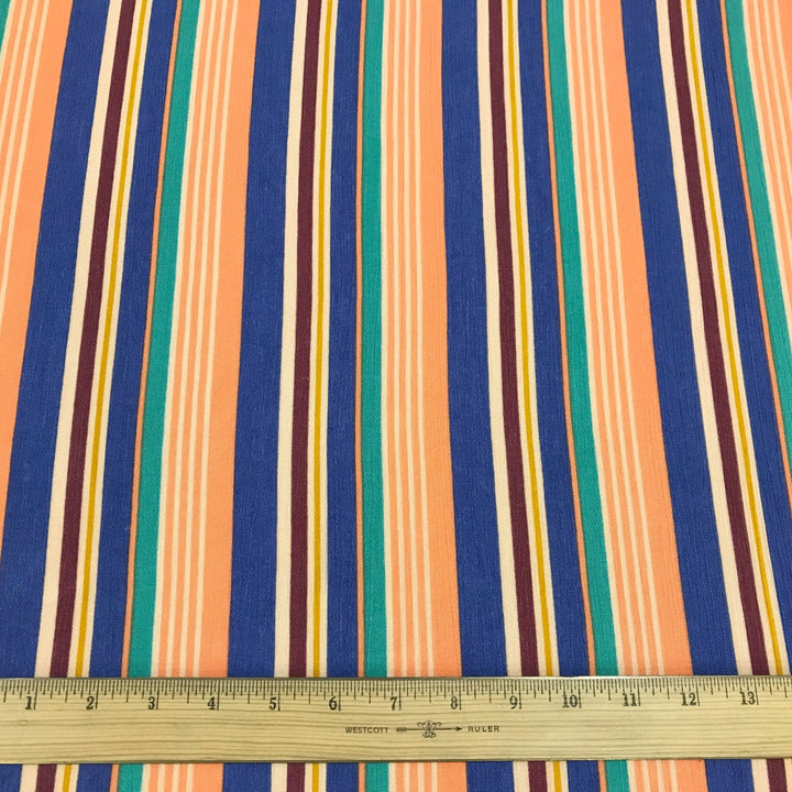 Rayon Crepe Cabana Stripe fabric in peach, periwinkle, and mint colors with flowing drape