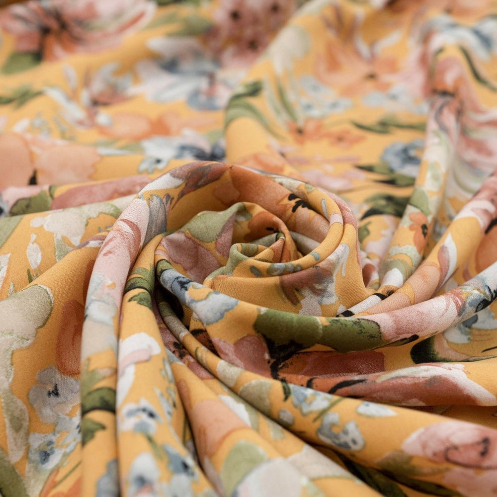 Rayon Poplin Golden Sunset Bloom fabric with marigold base, pumpkin, blue, and olive floral accents – 100% rayon sewing material