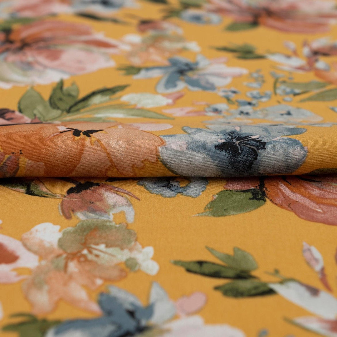 Rayon Poplin Golden Sunset Bloom fabric with marigold base, pumpkin, blue, and olive floral accents – 100% rayon sewing material