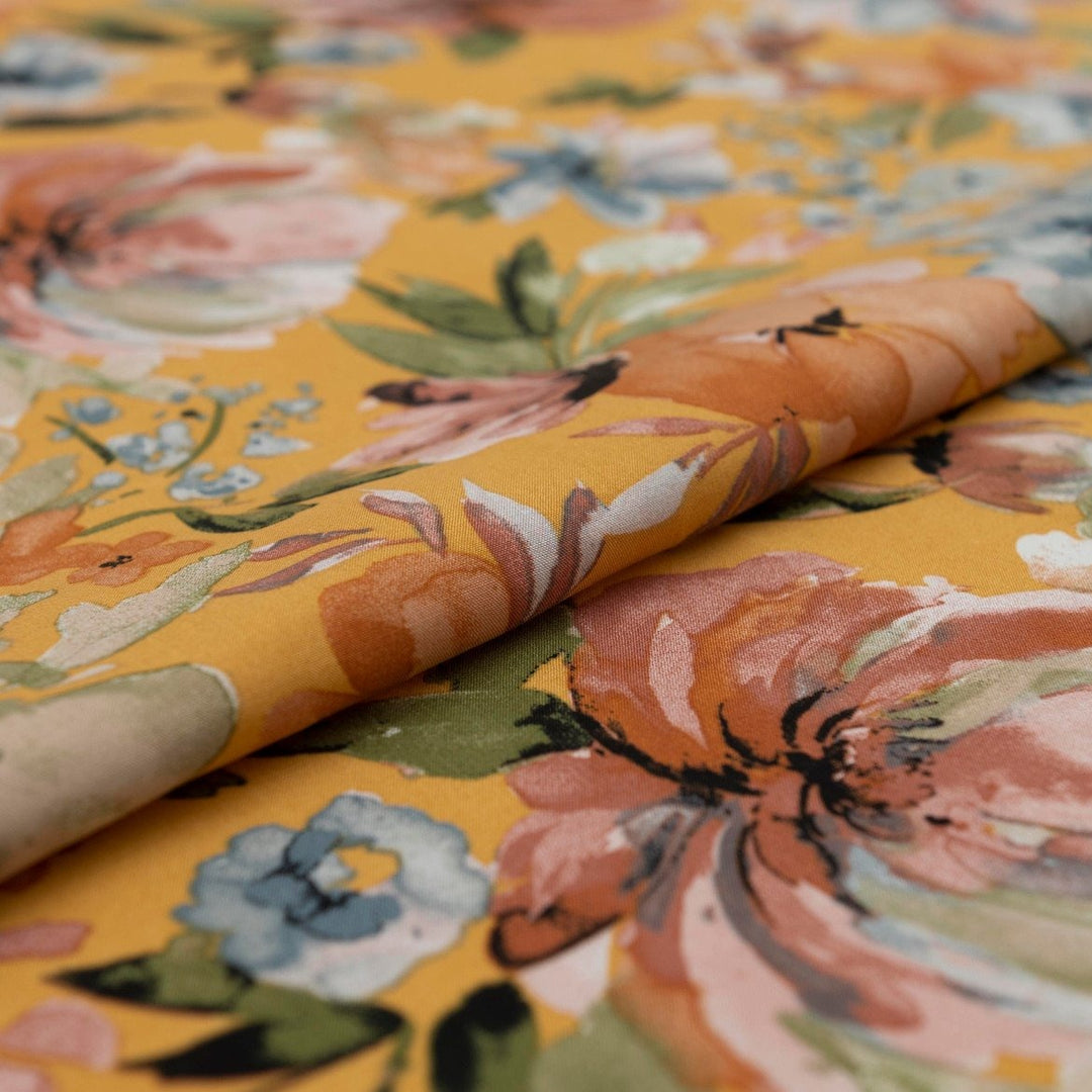 Rayon Poplin Golden Sunset Bloom fabric with marigold base, pumpkin, blue, and olive floral accents – 100% rayon sewing material