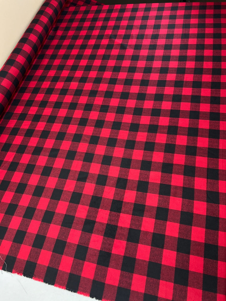 Italian cotton flannel fabric in red and black buffalo plaid, lightweight textile ideal for shirts, blouses, and casual wear.