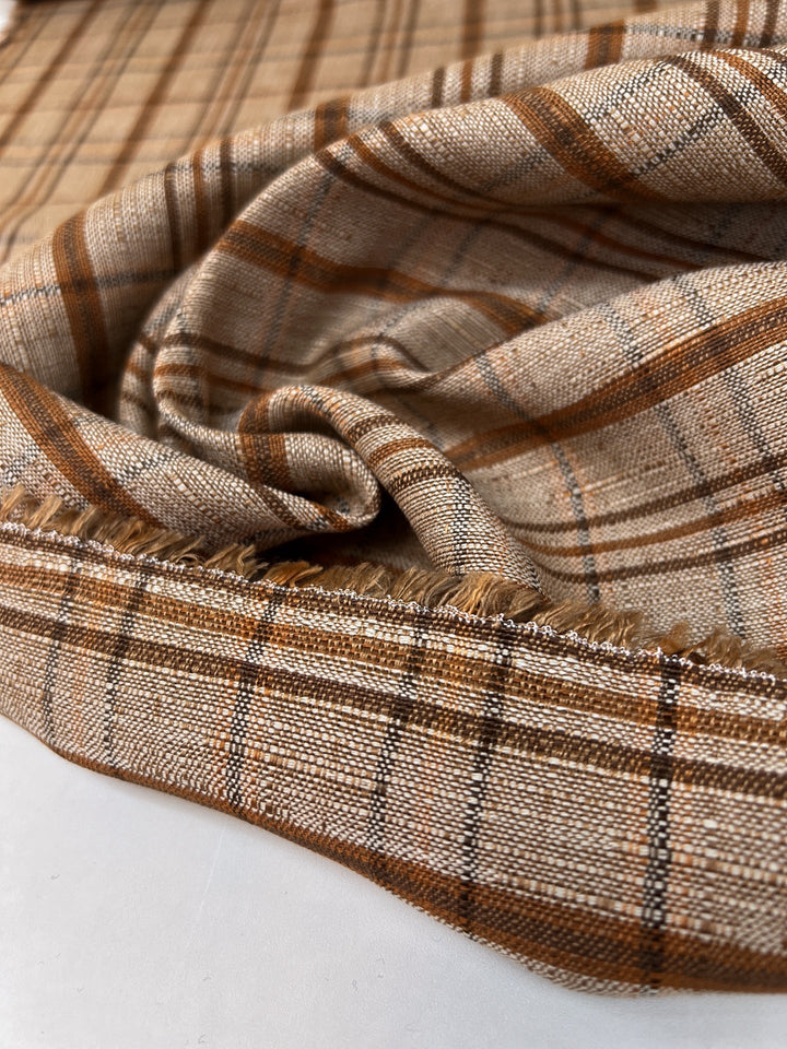 Italian plaid tweed fabric in browns and beige, viscose cotton blend, lightweight textile for structured coats, suiting, skirts, and dresses.