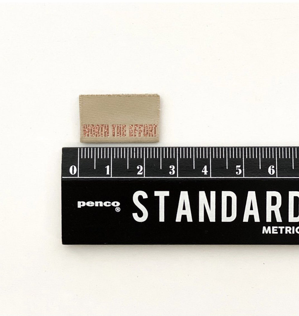 Luxury 'Worth the Effort' woven sewing labels in khaki green with rose gold metallic lettering - premium garment tags
