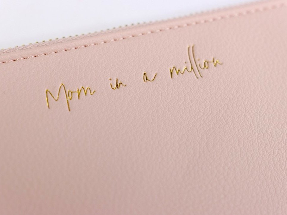 Everyday wristlet clutch in neutral color with removable strap and minimalist design.