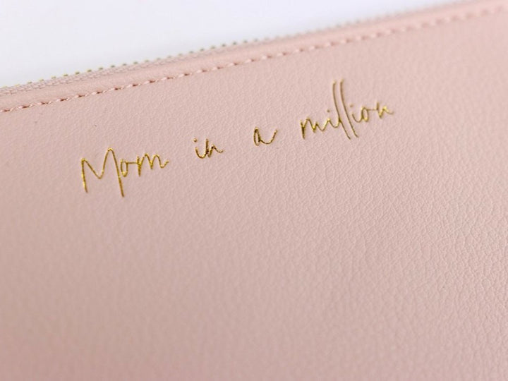 Everyday wristlet clutch in neutral color with removable strap and minimalist design.