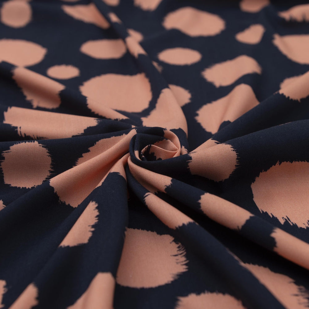 Rayon Challis fabric in navy with random coral dots, lightweight and drapey textile for sewing blouses, dresses, and skirts