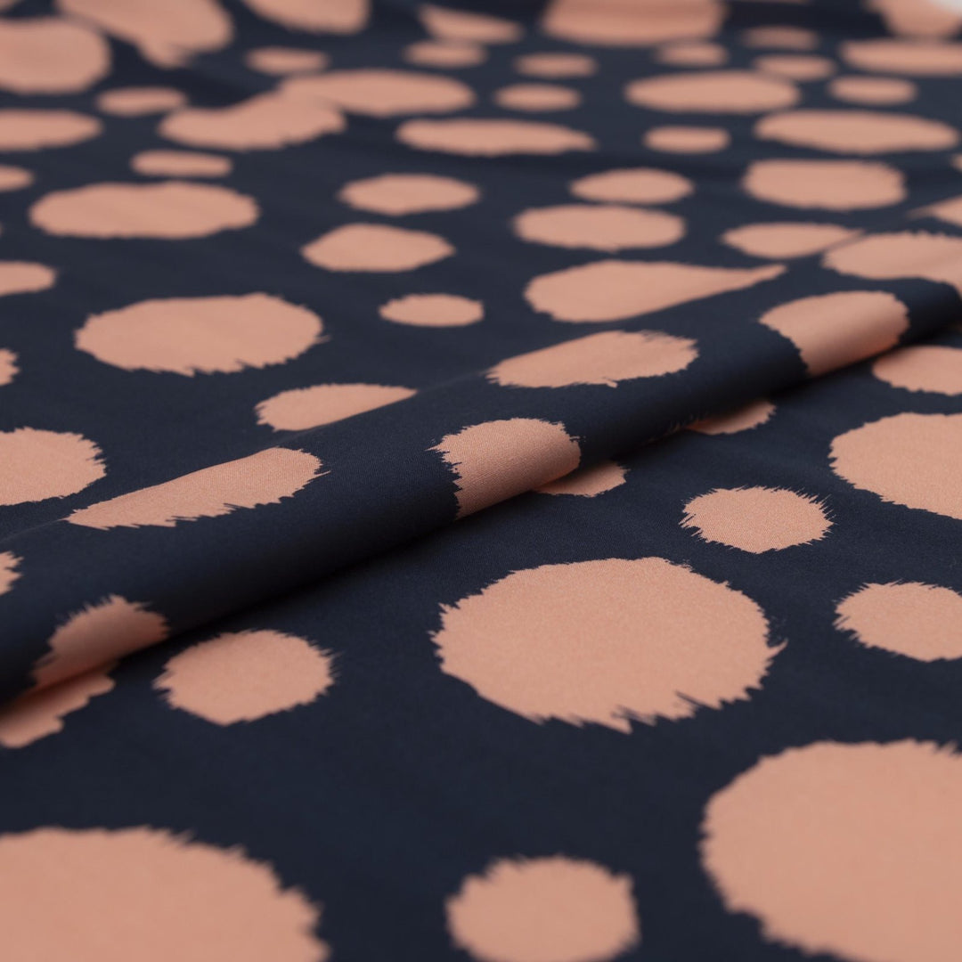 Rayon Challis fabric in navy with random coral dots, lightweight and drapey textile for sewing blouses, dresses, and skirts