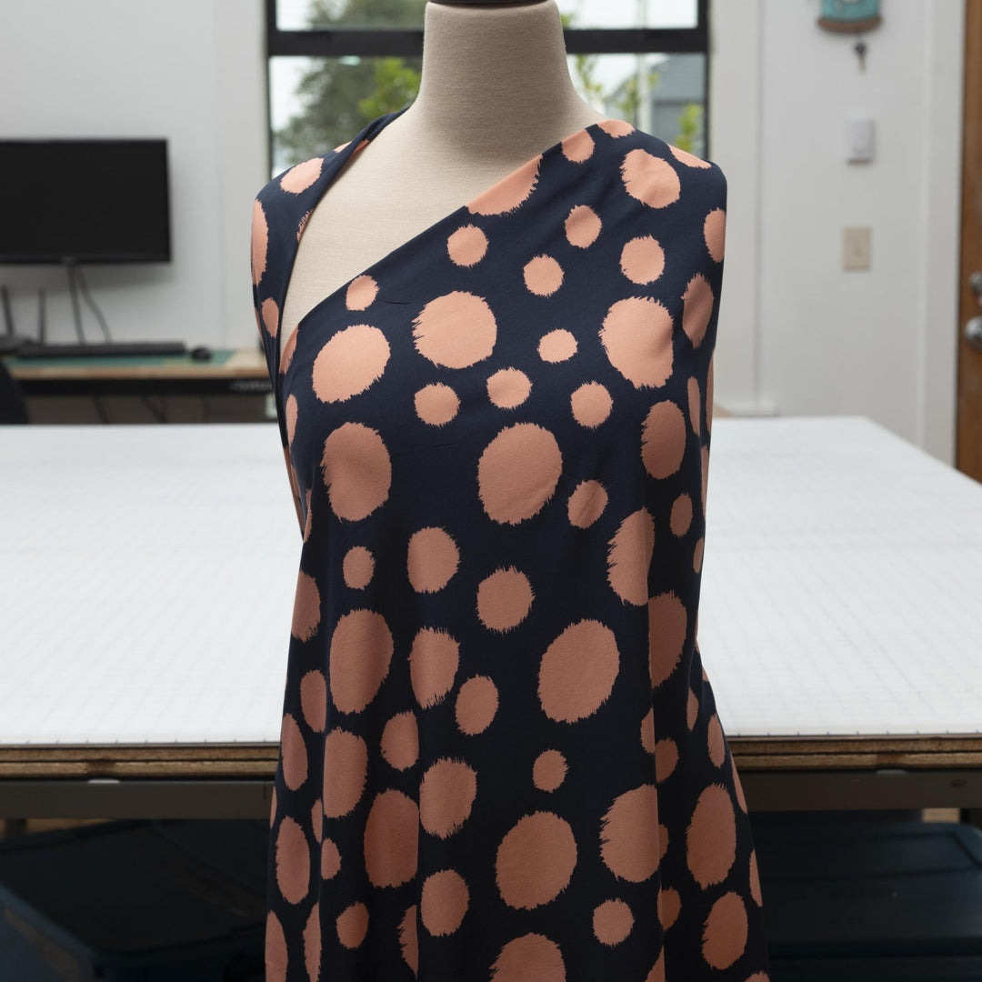 Rayon Challis fabric in navy with random coral dots, lightweight and drapey textile for sewing blouses, dresses, and skirts