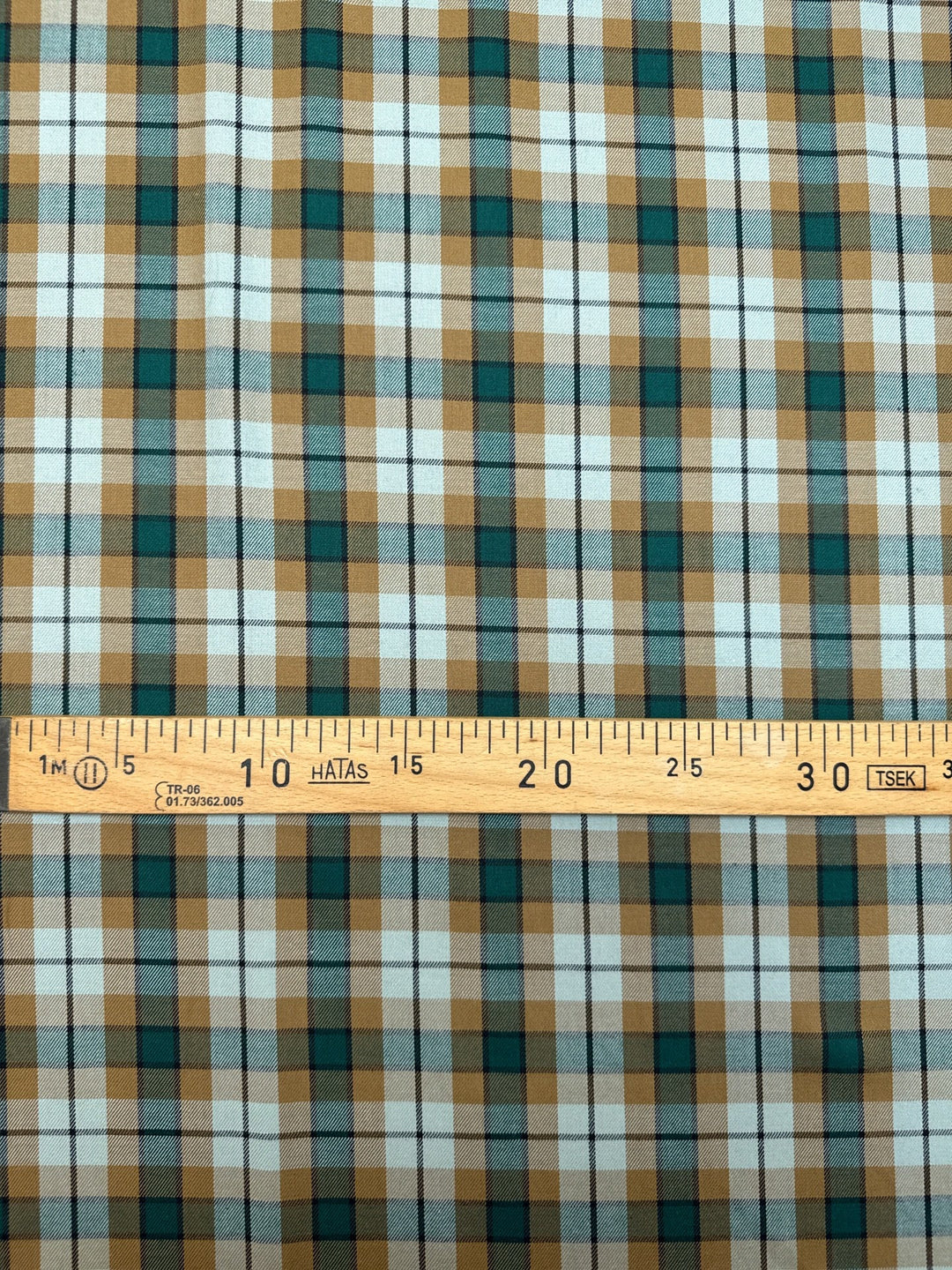 Italian cotton tweed fabric in cream, green, and brown plaid twill weave, lightweight and structured for coats, suiting, and dresses.