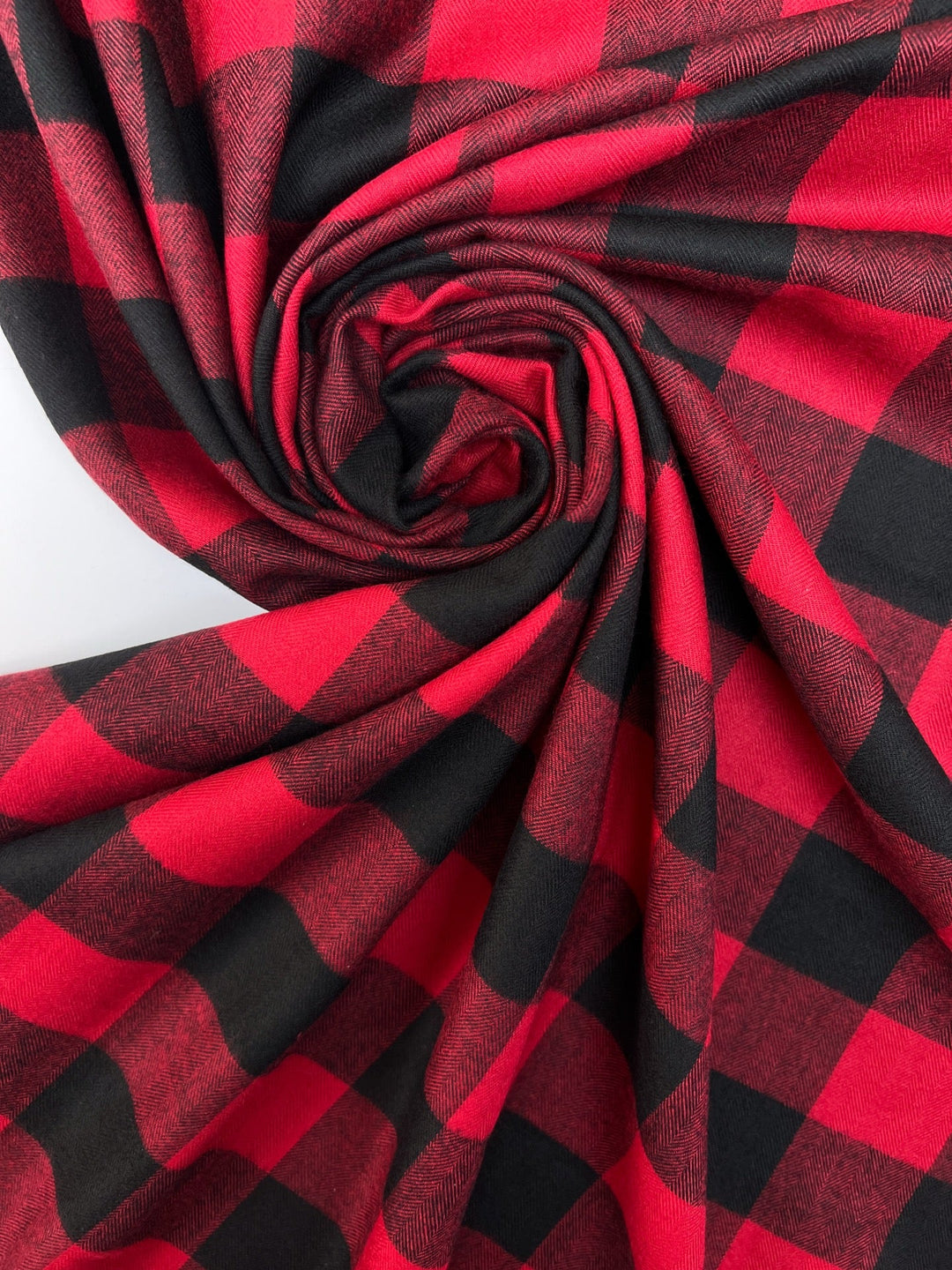 Italian cotton flannel fabric in red and black buffalo plaid, lightweight textile ideal for shirts, blouses, and casual wear.