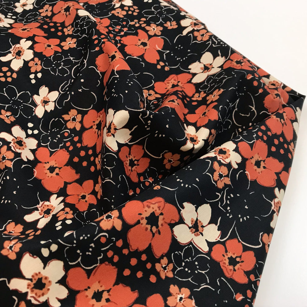 Fall floral cotton poplin fabric with orange blooms on black, 59-inch wide deadstock textile