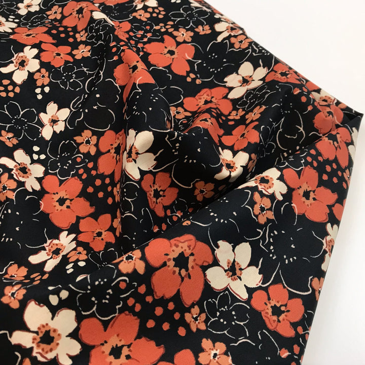Fall floral cotton poplin fabric with orange blooms on black, 59-inch wide deadstock textile