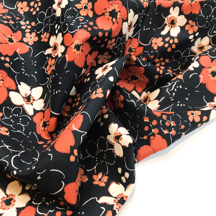 Fall floral cotton poplin fabric with orange blooms on black, 59-inch wide deadstock textile