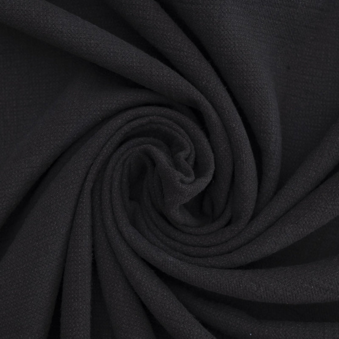 Crinkle Cotton Black 100% cotton fabric with textured finish for sewing pants, skirts, and dresses