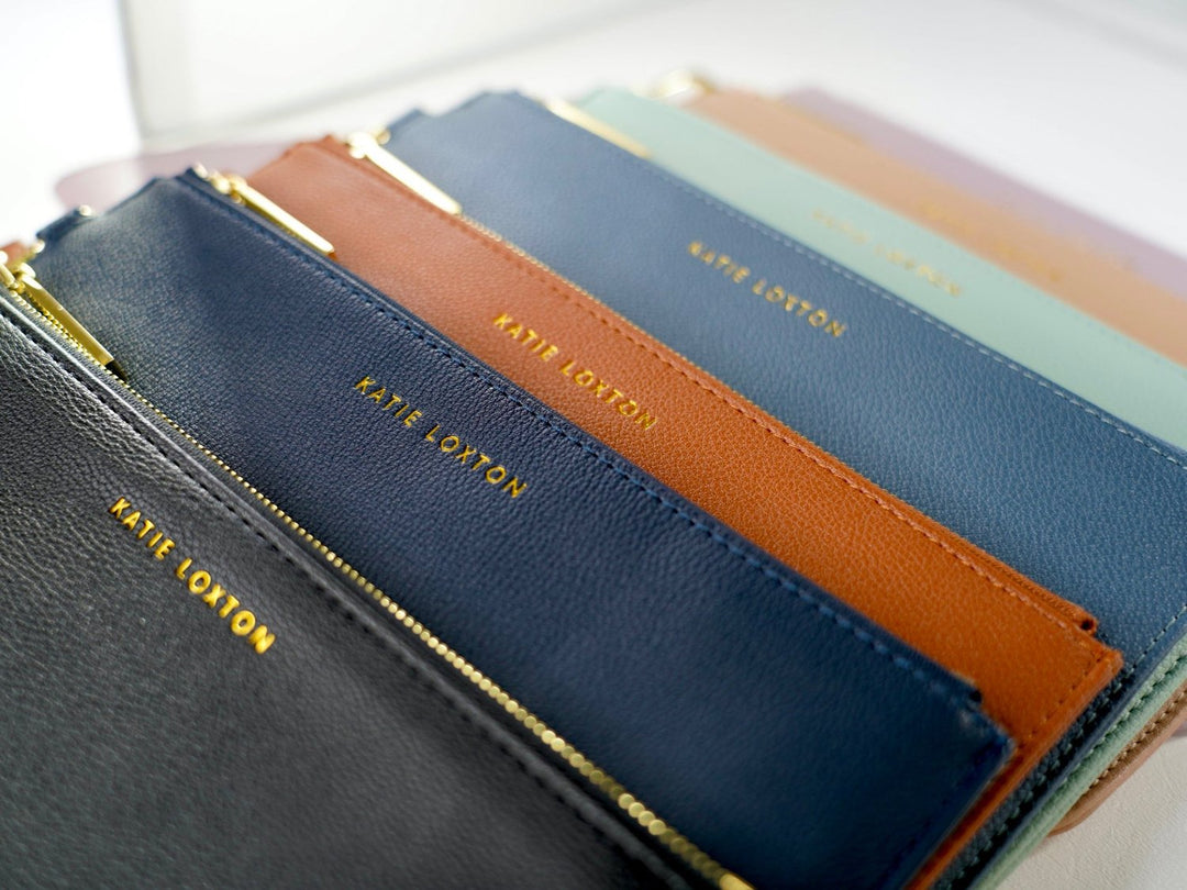 Everyday wristlet clutch in neutral color with removable strap and minimalist design.