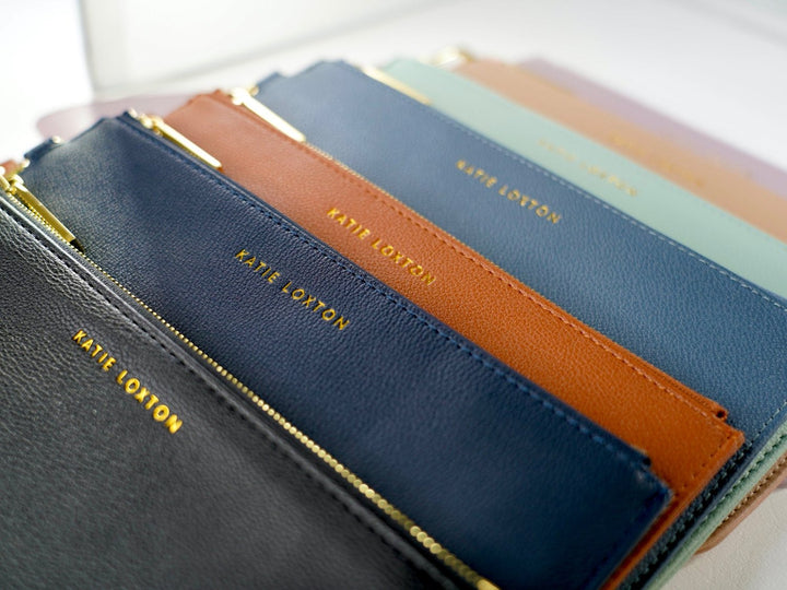 Everyday wristlet clutch in neutral color with removable strap and minimalist design.