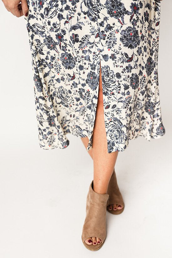 Chalk & Notch Orchid Midi Dress sewing pattern featuring wrap bodice, flowing midi skirt, and sleeve options with ruffle or long gathered sleeves.