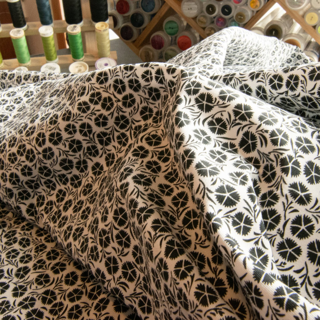Close-up texture of monochrome floral stretch poplin showing botanical pattern detail

