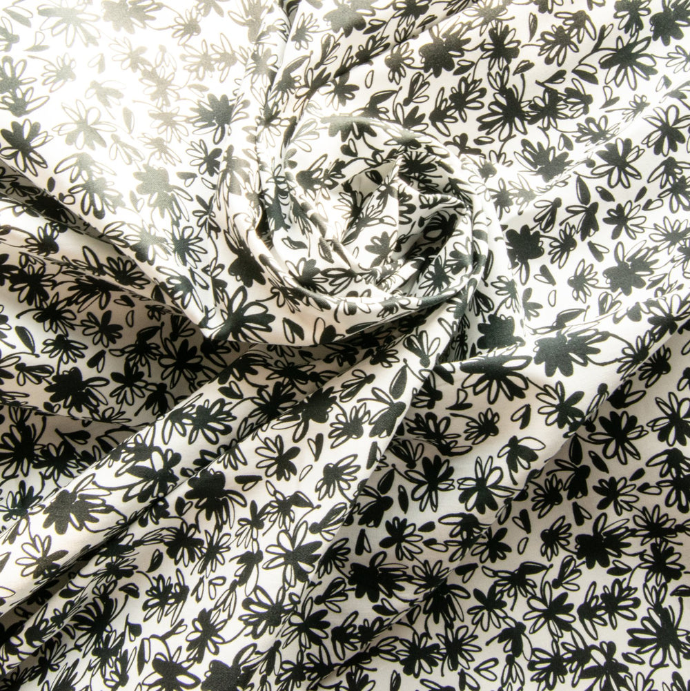 Close-up texture of monochrome floral stretch poplin showing botanical pattern detail


