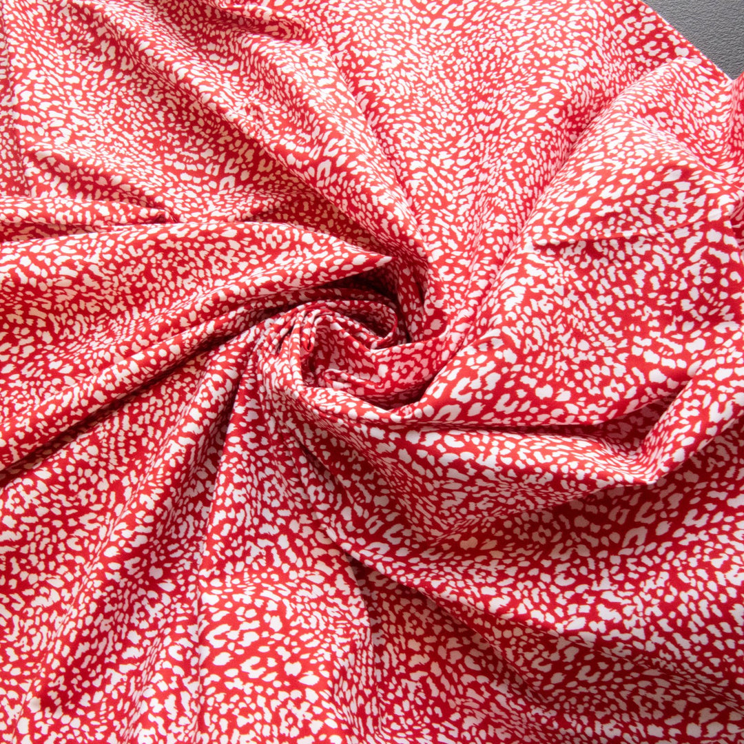 Red and white abstract print French cotton poplin fabric with 4% elastane content

