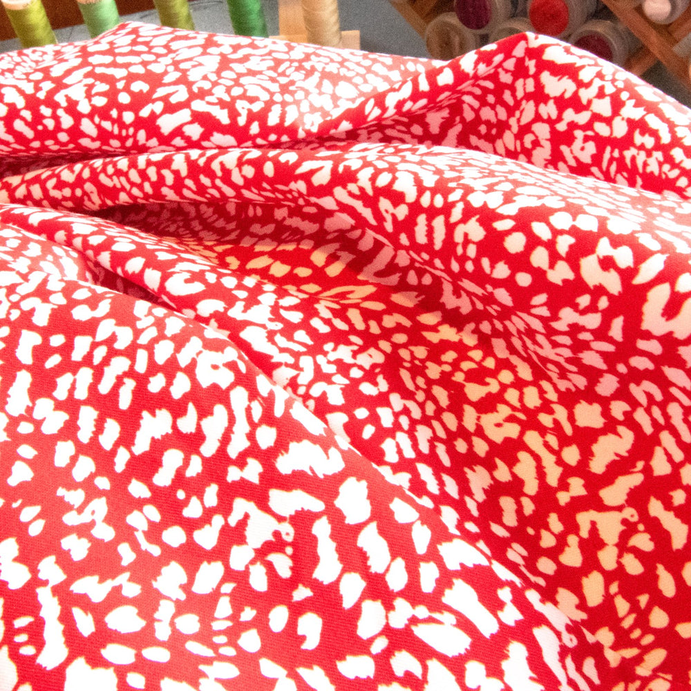Red and white abstract print French cotton poplin fabric with 4% elastane content


