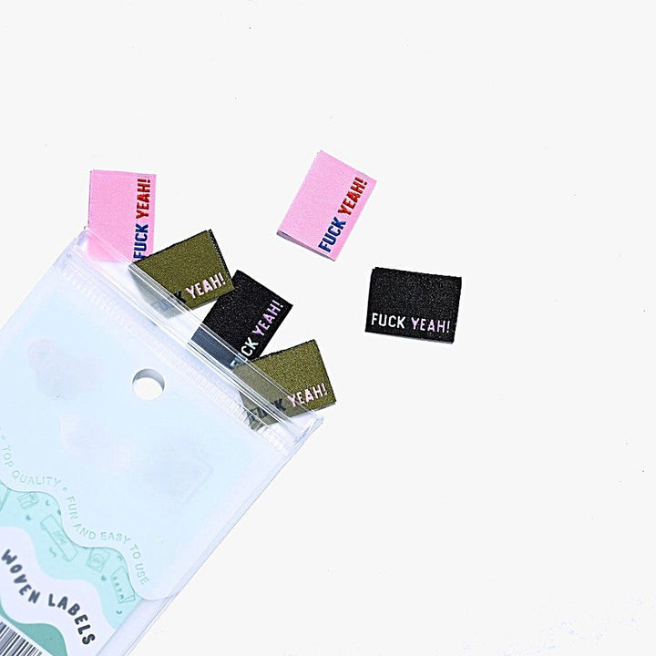 F*ck Yeah woven labels by Kylie and the Machine showing three color variations: black/blue/purple, khaki/black/pink, and pink/navy/rust side seam tags